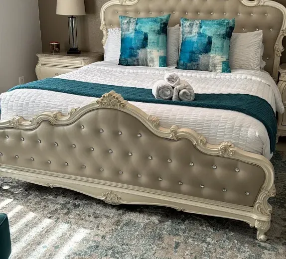Staged Airbnb bedroom with hotel-style rolled towels after an Ire Cleaning Services turnover clean