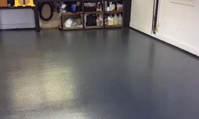 Clean epoxy-coated garage floor with organized workbench after an Ire Cleaning Services garage cleaning