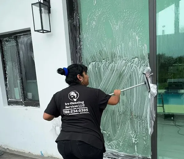 Ire Cleaning Services team member cleaning a glass door near our Sweetwater home base