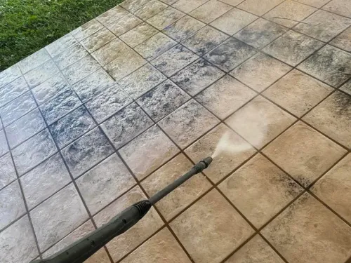 Pressure washing removing dirt and mildew from an outdoor patio